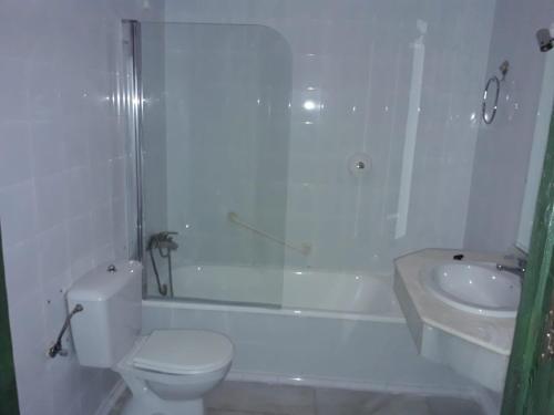 a white bathroom with a toilet and a sink at Sabiñanigo Camp & Hotel in Sabiñánigo