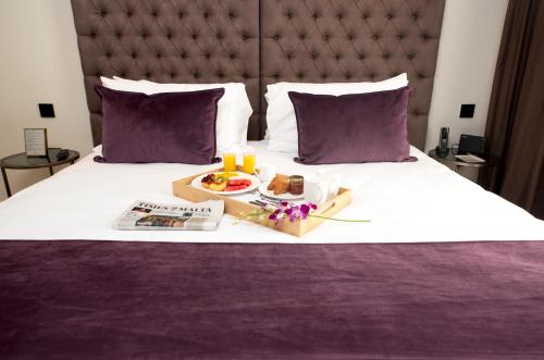 een dienblad met eten op een bed met een dienblad met eten bij Urban Valley Resort & Spa in San Ġwann