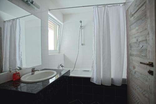 a white bathroom with a sink and a shower at Apartmán Luky in Vyšné Ružbachy