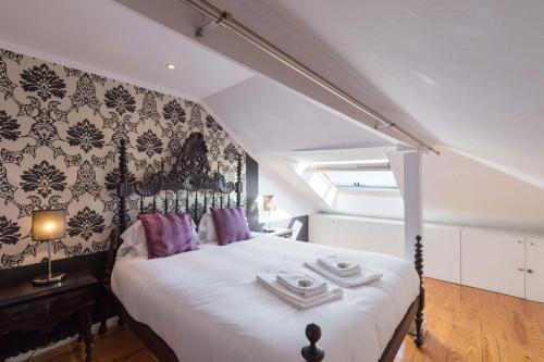リスボンにあるTravelingToLisbon 120 - Alfamaのベッドルーム(紫色の枕が付いた大きな白いベッド付)