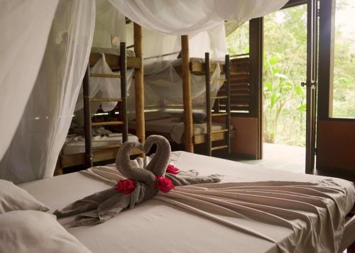 Una cama con dos cisnes encima. en Amazonita Ecolodge, en Dos Brazos