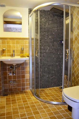 a bathroom with a shower and a sink and a toilet at Küçükköy Otel in Ayvalık