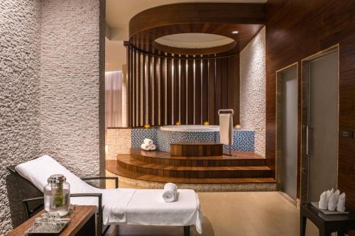 einen Wellnessraum mit einer Badewanne und einem Tisch in der Unterkunft Swissôtel Living Al Ghurair in Dubai