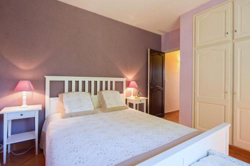 - une chambre dotée d'un lit blanc avec deux tables et deux lampes dans l'établissement La Régalide, à Le Tignet