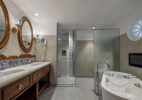 
a bathroom with a tub, sink, toilet and shower at Taj Exotica Resort & Spa, Goa in Benaulim
