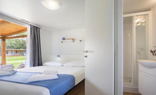 a bedroom with two beds and a sink at Maistra Camping Polari Mobile homes in Rovinj