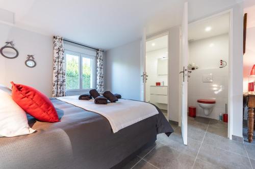 a bedroom with a bed and a bathroom with a toilet at Le Clos Lamy in Mont-près-Chambord