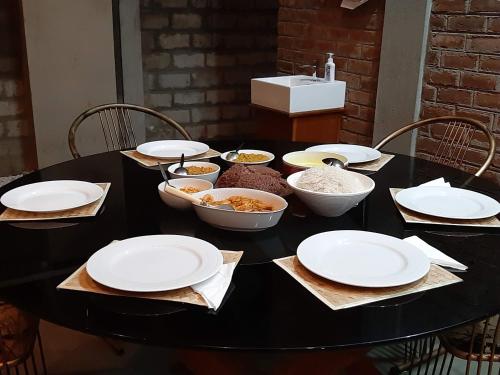 a black table with plates and bowls of food on it at Blue Sands Beach Resort in Pasikuda