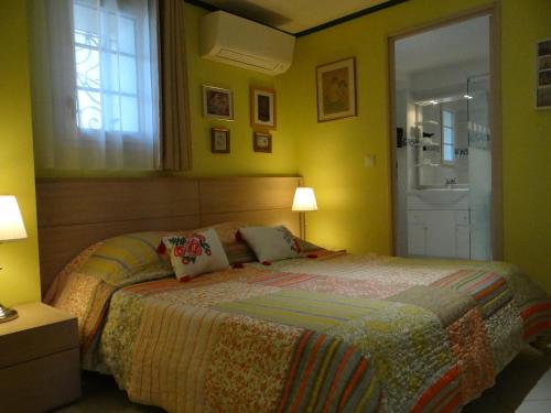 イエールにあるAppartement T2 50m² vue mer Presqu'il de Giens. RCのベッドルーム1室(黄色い壁のベッド1台、窓付)