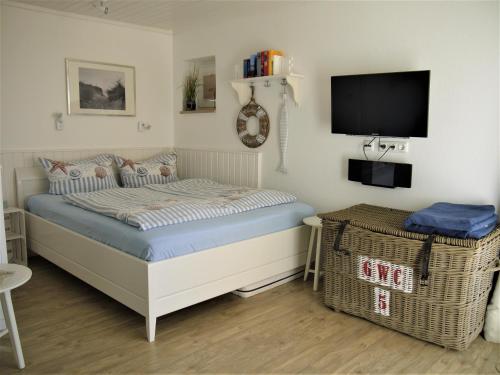 a bedroom with a bed and a flat screen tv at Strandperle 3 in Scharbeutz