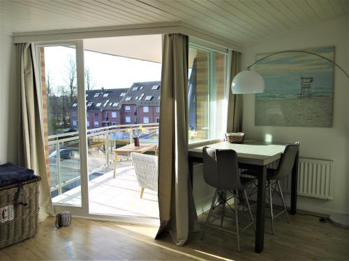 a dining room with a table and a balcony at Strandperle 3 in Scharbeutz