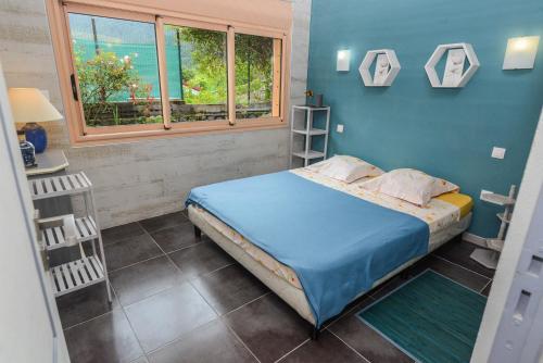 a small bedroom with a bed and a window at La Croix du Sud 2 - Bas de Villa Cilaos in Cilaos