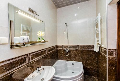 a bathroom with a tub and a sink and a mirror at Comfortable House on Marjanishvili in Tbilisi City