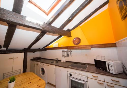 une cuisine avec des murs jaunes et blancs et une table dans l'établissement La Casa Roja de Saioa, à Lekeitio