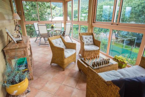 a screened in porch with wicker chairs and a table at La Croix du Sud 1 in Cilaos