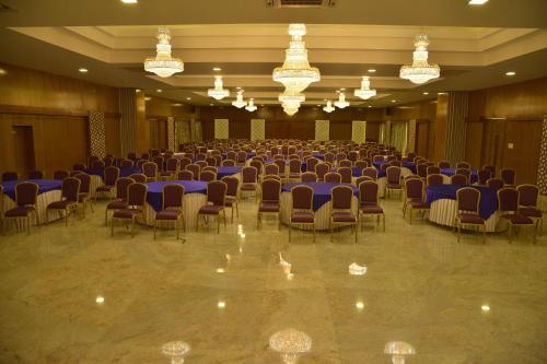 a large room with chairs and tables and chandeliers at Esthell Village Resort in Mahabalipuram