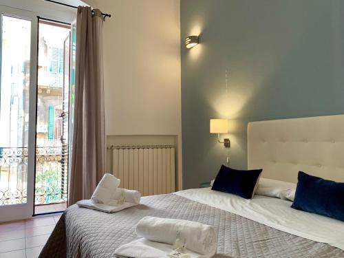 una camera da letto con un grande letto con asciugamani di A due passi dal ponte a Taranto