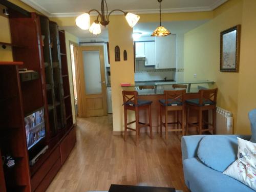 a living room with a couch and a kitchen at Apartamento rural Felechosa in Felechosa