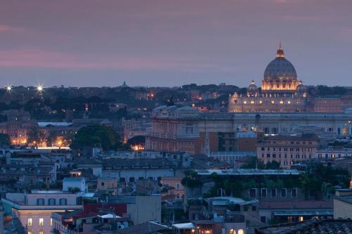 a view of a city skyline at night at Rocco Forte Hotel De La Ville in Rome