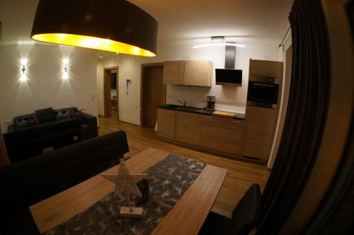 a living room with a couch and a table and a kitchen at Appartements Klotz in Ehrwald