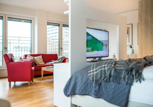 a room with a bed and a living room with a tv at THE FLAG Oskar M. in Frankfurt/Main