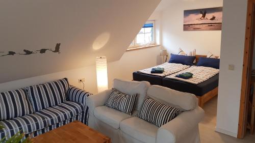 a living room with a couch and a bed at Ferienwohnung Kranichblick in Zingst