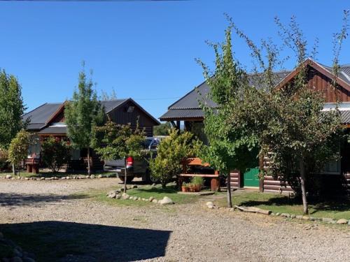 a house with a parking lot in front of it at Cabañas Costa del Percy in Trevelin