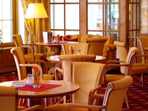 a restaurant with tables and chairs and windows at Das Pfandler in Pertisau