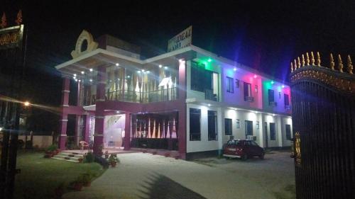 a lit up building at night with a car in front at Hotel the Ideal in Kushinagar