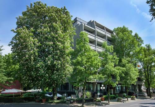 a large building with trees in front of it at Rheinhof by Gerda Good Living - Digital Access in Meerbusch