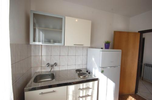 a small kitchen with a sink and a refrigerator at Apartments Dida in Njivice