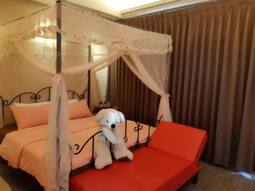 雙溪區的住宿－雙禾庭園民宿 (Shuanghu Garden B&B)，一只白泰迪熊坐在天篷床上