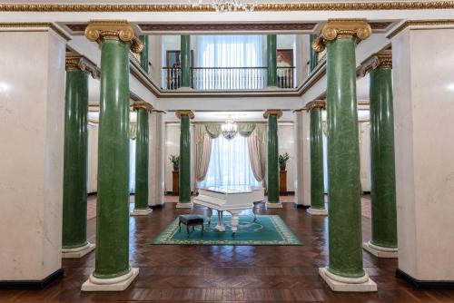 a room with green columns and a bench in the middle at Legendary Hotel Sovietsky in Moscow