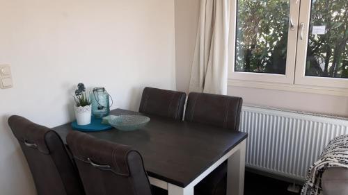 a dining room table with four chairs and a window at Chalet 36 in Giethoorn