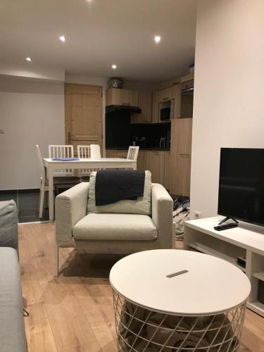 un salon avec un canapé et une table dans l'établissement Charmant Appartement Centre Ville Valloire, à Valloire