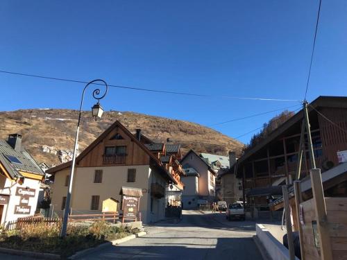 une rue dans une ville avec une montagne en arrière-plan dans l'établissement Charmant Appartement Centre Ville Valloire, à Valloire