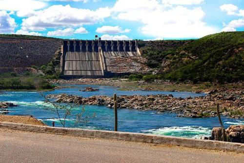 a dam on a river next to a road at Casa de Temporada Bem Estar in Piranhas