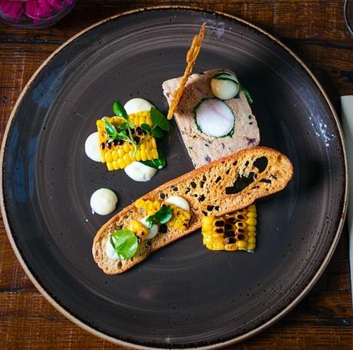 a black plate with eggs and bread on a table at The Congresbury Arms in Congresbury