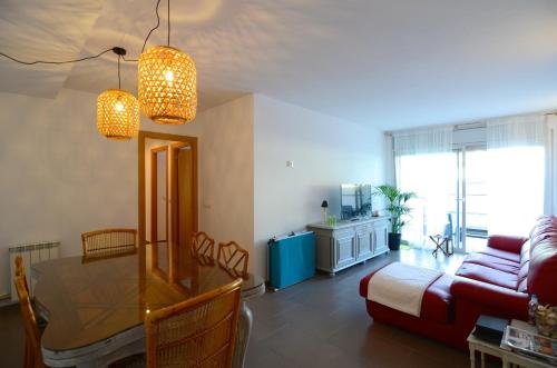 ein Wohnzimmer mit einem Tisch und einem Sofa in der Unterkunft PLATJA 32 1º 1ª. in L'Estartit