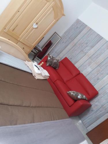 a red couch sitting in the middle of a room at Locanda 130 in Fonni