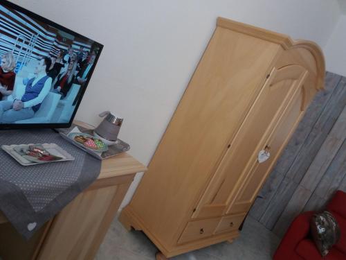 a wooden cabinet with a tv on top of a desk at Locanda 130 in Fonni