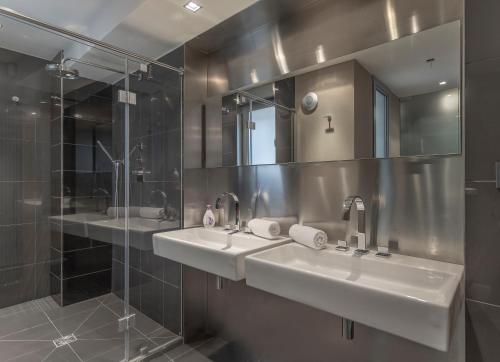 a bathroom with two sinks and a shower at LUXURY CENTRAL DUPLEX WITH TERRACE in Prague