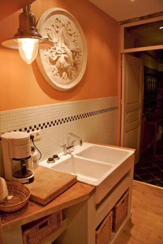 a bathroom with a sink and a plate on the wall at Studio Rempart in Brussels