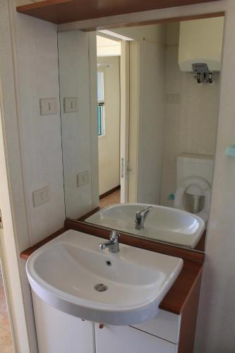 a bathroom with a sink and a mirror at Camping Fontana delle Rose in Mattinata