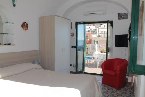 a bedroom with a bed and a red chair at Attico del Cavaliere in Atrani
