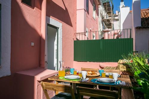 a wooden table with plates of food on a balcony at Hip Tailor Made Flat in Bairro Alto in Lisbon