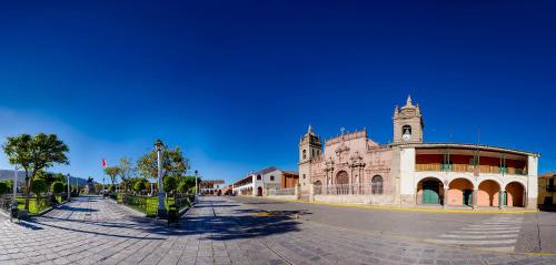 un grande edificio con una torre dell'orologio su una strada di Altipacha Ayacucho Hotel ad Ayacucho
