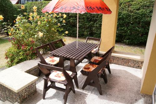 a wooden table with two chairs and an umbrella at Wakacje u Magdy in Rowy
