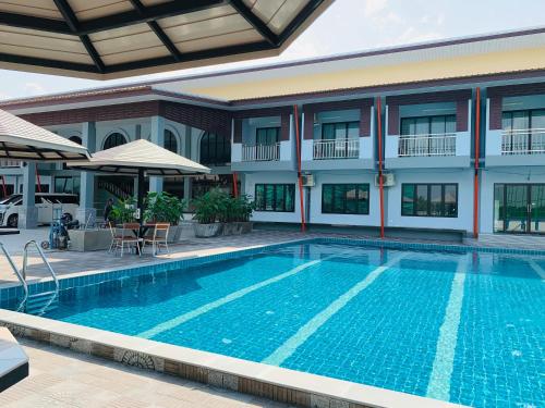 una piscina frente a un edificio en โรงแรมมาลินี en Surin
