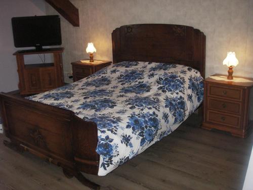 um quarto com uma cama azul e branca com duas mesas de cabeceira em gite violette et pierrot em Masevaux